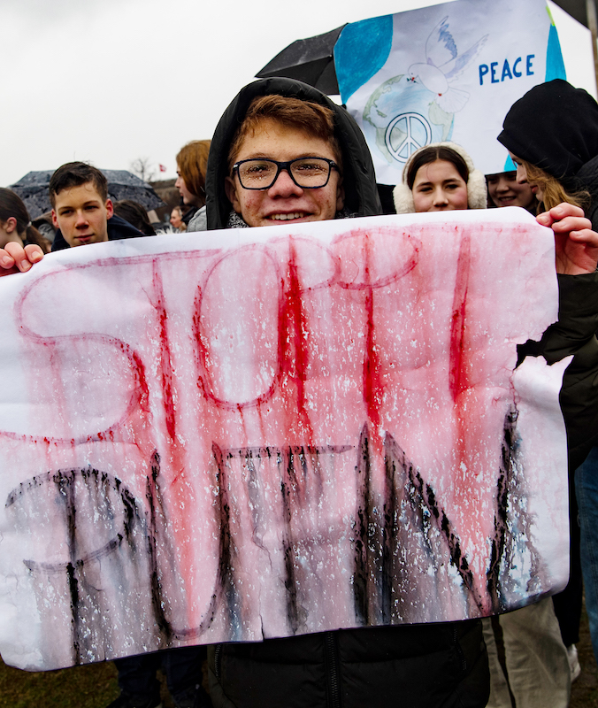 Foto: Schüler hält Plakat mit Aufschrift "Stoppt Putin" 