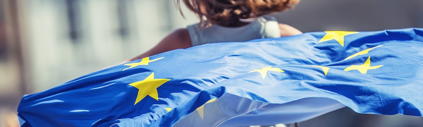 Foto: Mädchen läuft mit Europaflagge die Straße entlang