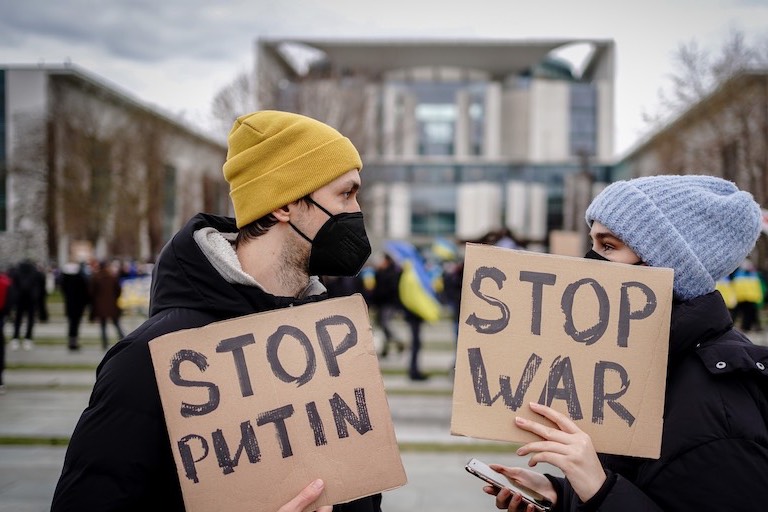 Foto: Menschen nehmen mit Plakaten mit der Aufschrift „Stop Putin“ und „Stop war“ an einer Demonstration gegen den Krieg in der Ukraine vor dem Bundeskanzleramt teil.