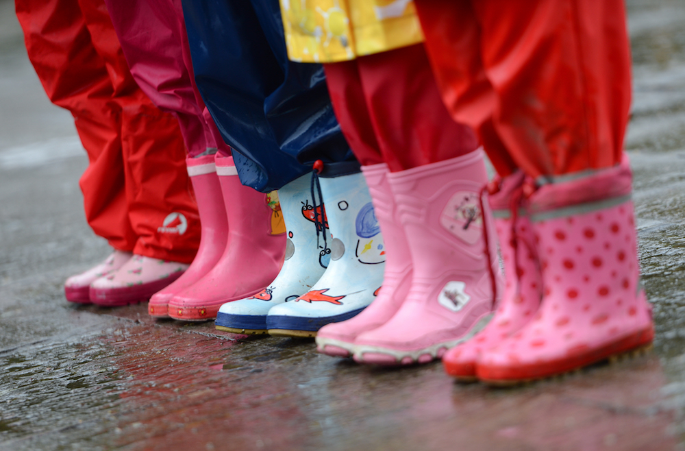 Kinder in Gummistifeln stehen im Regen. (Foto:dpa)