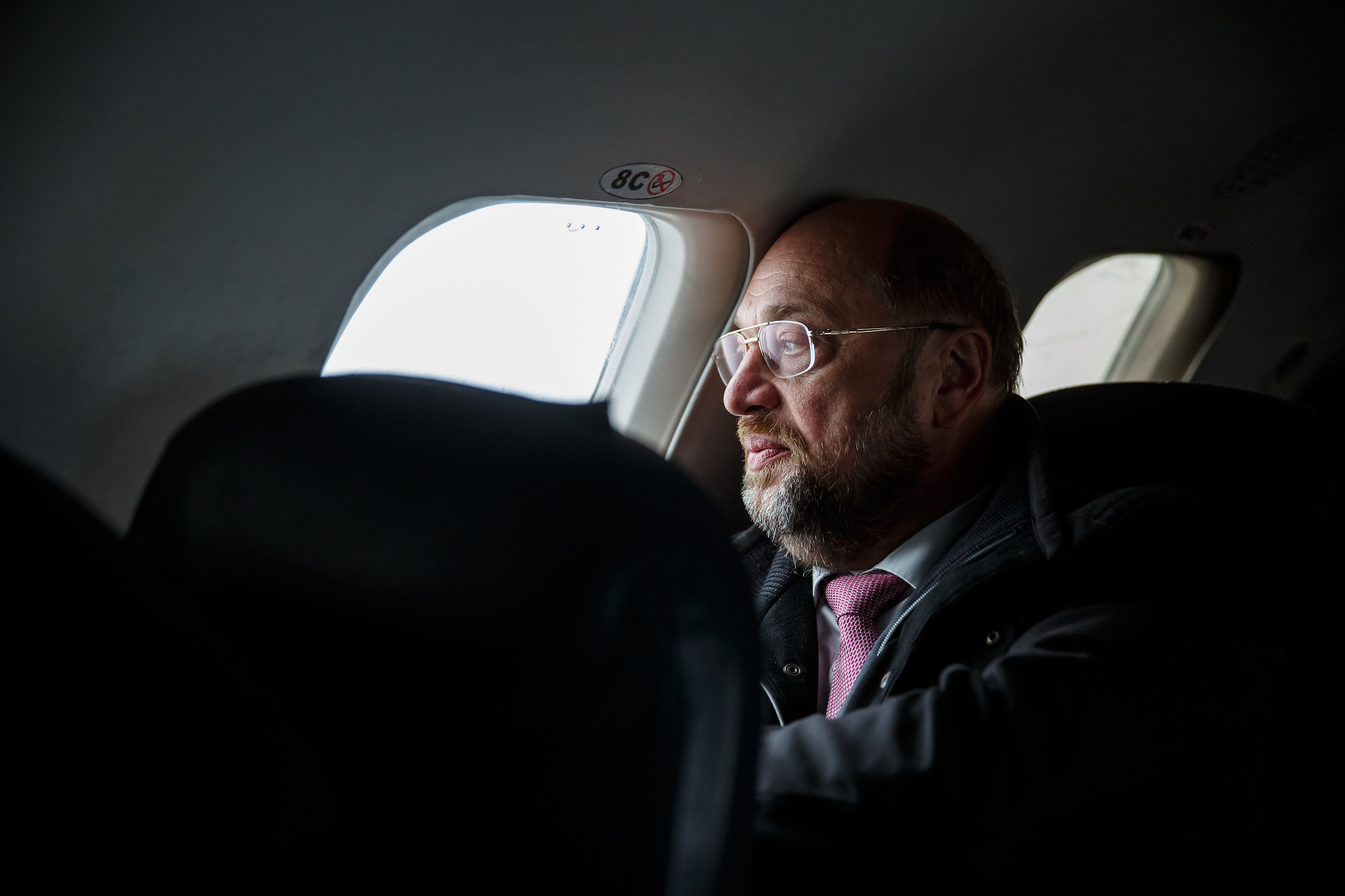Foto: Martin Schulz sitzt in einem Flugzeug und schaut aus dem Fenster