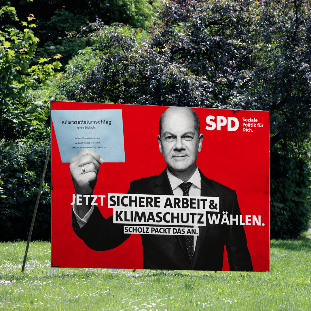 Foto: SPD-Plakat zur Bundestagswahl zum Thema Arbeit & Klimaschutz steht auf Grünfläche 