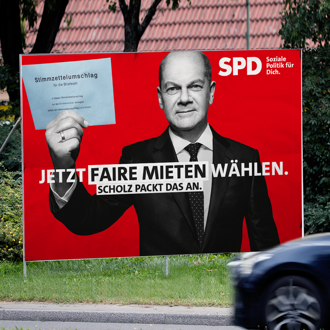 Foto: SPD-Plakat zur Bundestagswahl zum Thema fsire Mieten steht auf Grünfläche 