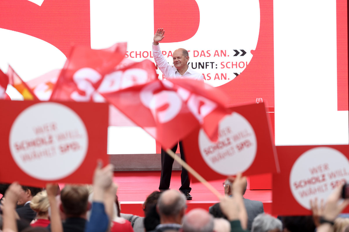 Foto: Olaf Scholz winkt Fahnen schwenkenden SPD-Anhängern zu