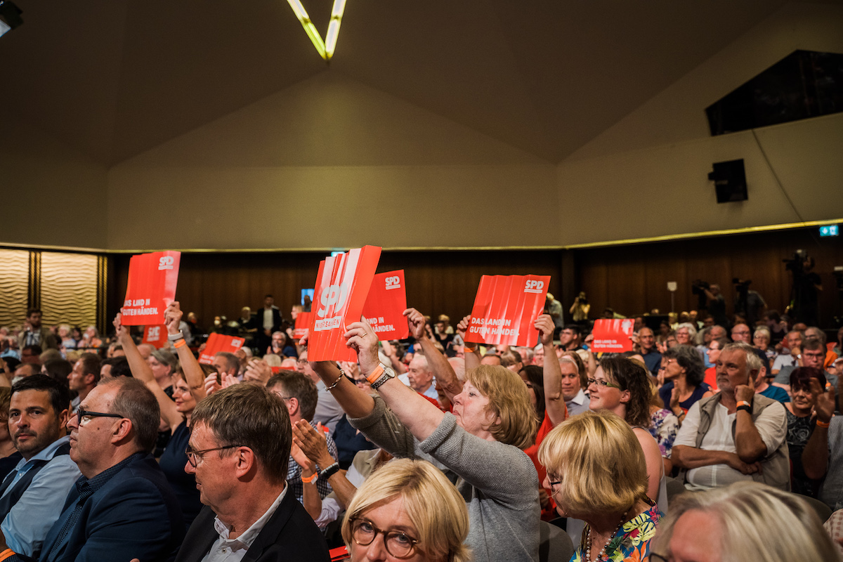 Foto: Menschen halten Schilder mit SPD-Claim "Das Land in guten Händen" in die Höhe