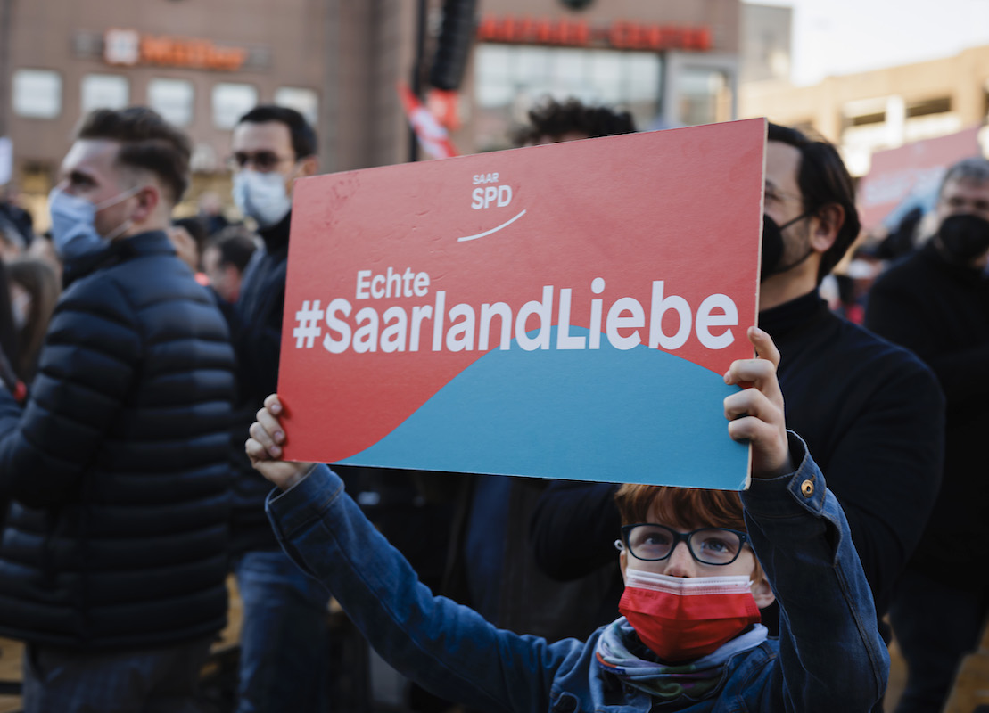 Foto: Kind hält Schild mit Aufschrift "Echte #SaarlandLiebe" hoch