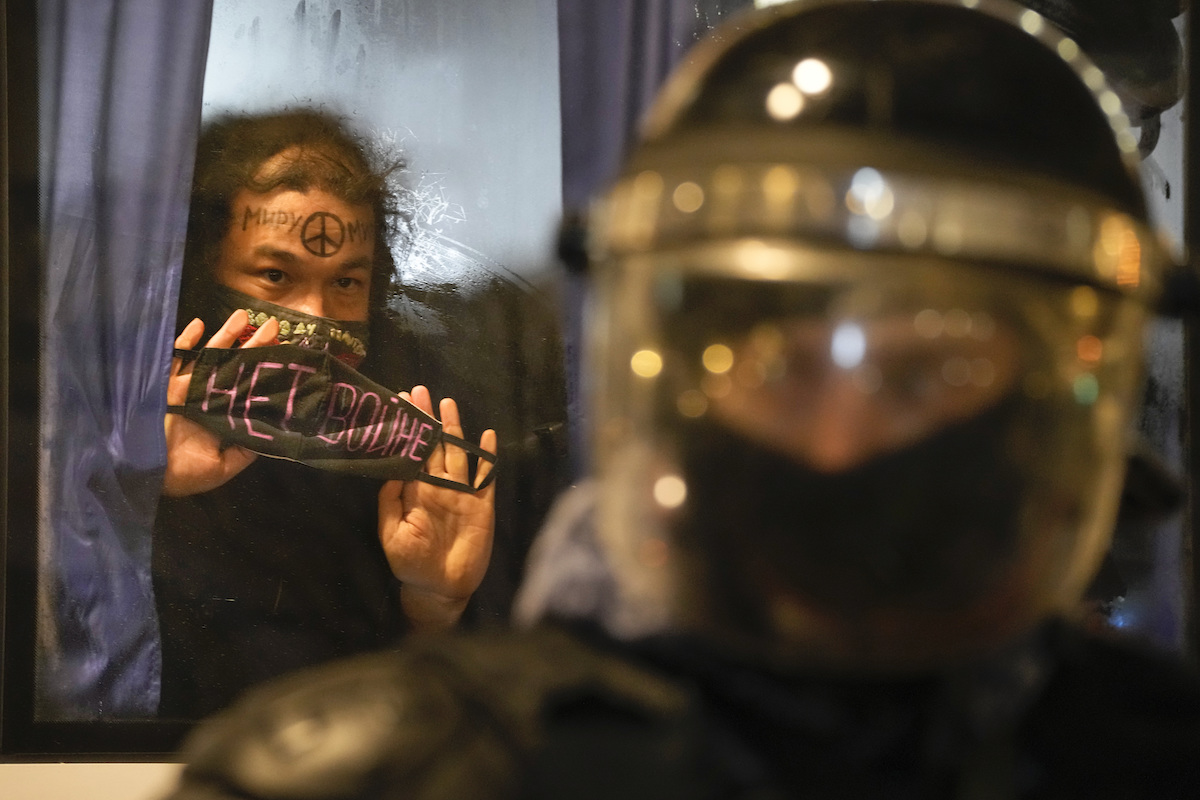 Foto: Ein in St. Petersburg festgenommener Demonstrant zeigt aus einem Polizeibus ein Schild mit der Aufschrift "Kein Krieg!".