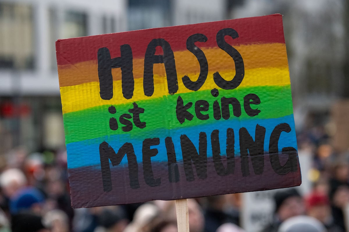 Foto: Demonstrierende halten ein Plakat „Hass ist keine Meinung“ hoch. 