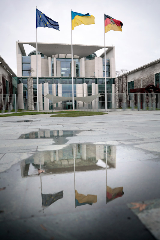 Foto: Vor dem Bundeskanzleramt ist neben der schwarz-rot-goldene Bundesflagge und Europaflagge die ukrainische Flagge gehisst. 