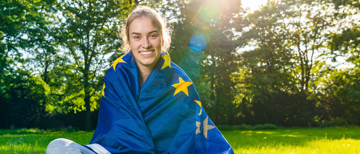 Foto: Eine junge Frau im Park hat sich die Europaflagge umgehängt