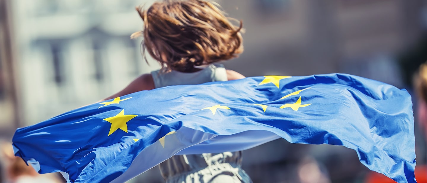 Foto: Mädchen läuft mit Europafahne durch eine Straße