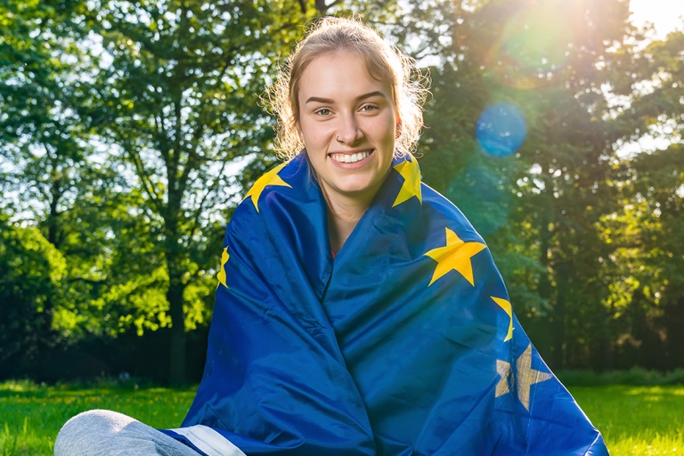 Foto: Eine junge Frau im Park hat sich die Europaflagge umgehängt