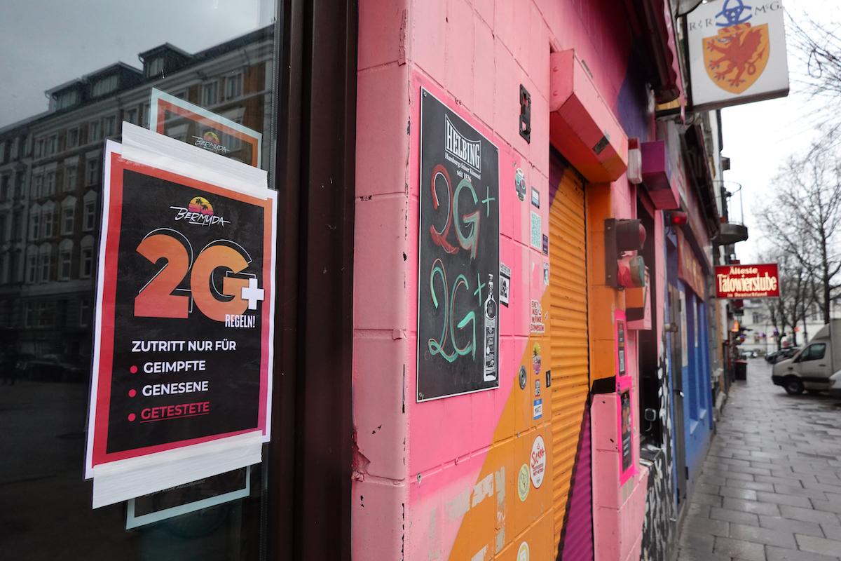 Foto: Ein Schild mit der Aufschrift „2G+“ hängt in einem Fenster einer Gaststätte.