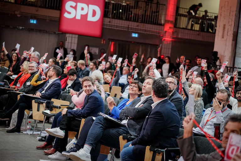 Foto: Kevin Kühnert, Saskia Esken, Lars Klingbeil und Hubertus Heil nehmen am SPD-Debattenkonvent teil, während die Delegierten für die Abschlussabstimmung ihre Stimmkarten heben.