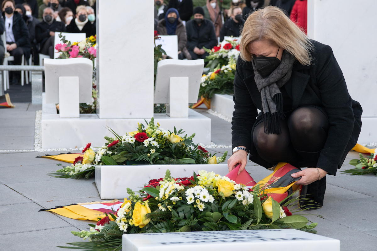 Foto: Nancy Faeser legt einen Blumenkranz auf ein Grab eines der Opfer der Anschläge von Hanau 