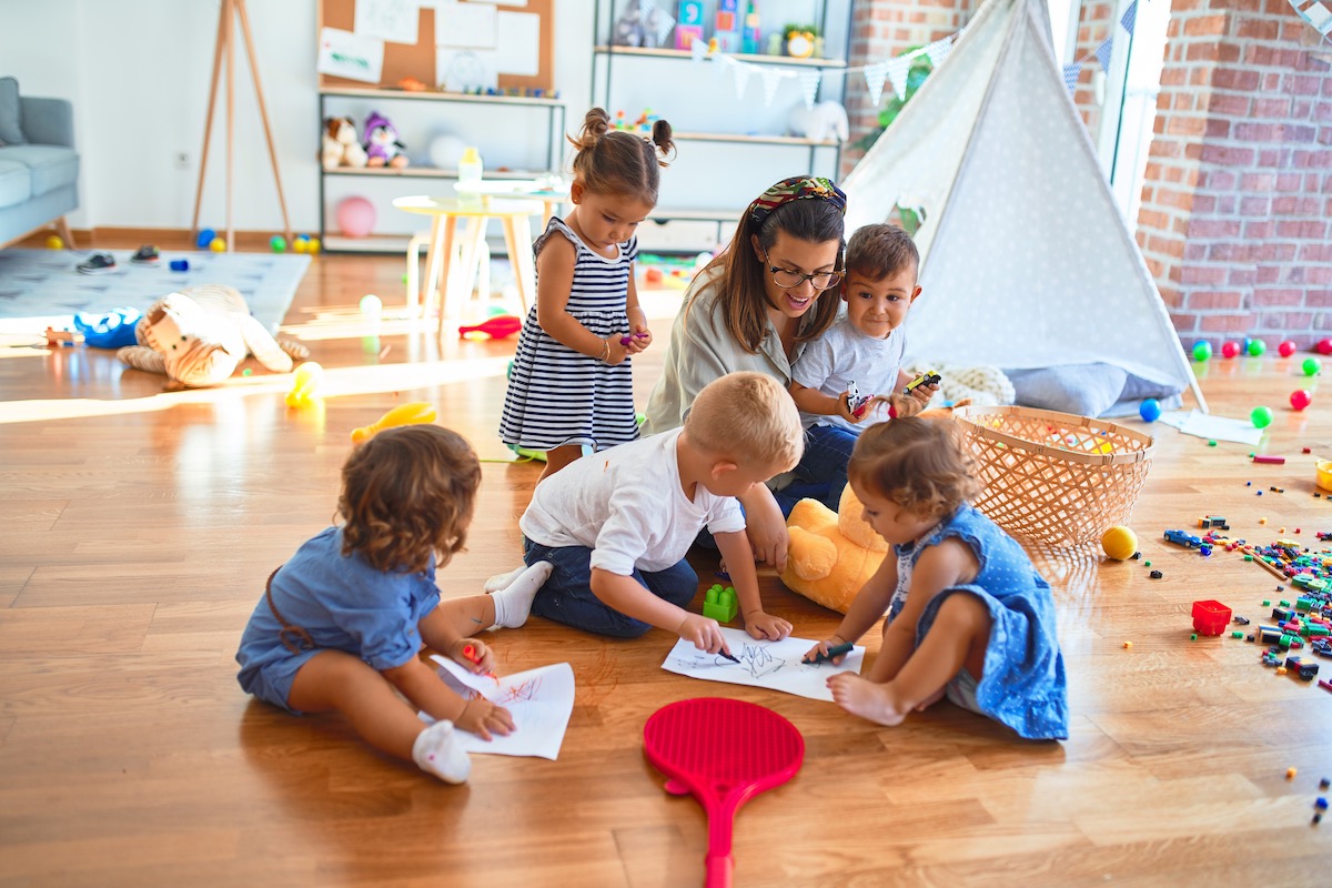 Foto: Erzieherin spielt mit Kindern in Kita