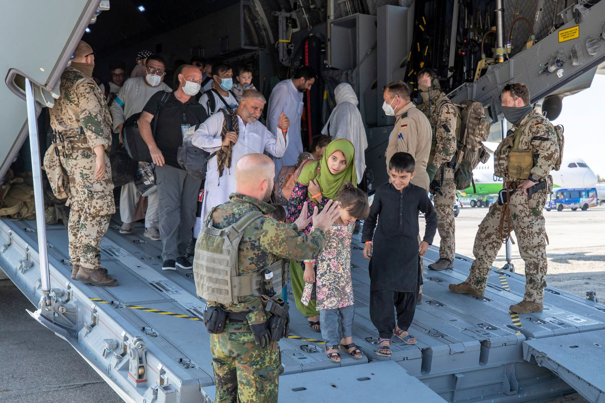 Foto: In Taschkent (Usbekistan) werden kurz nach der Landung Evakuierte aus Afghanistan von deutschen Sicherungskräften aus dem Airbus geleitet.