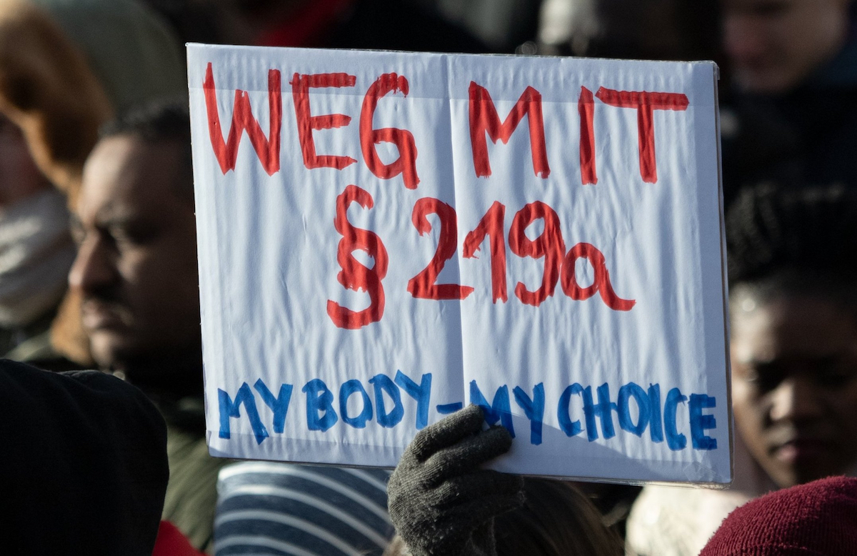 Foto: Teilnehmer einer Demonstration halten ein Schild mit Aufschrift "Weg mit Paragraf 219a - My Body - my Choice"
