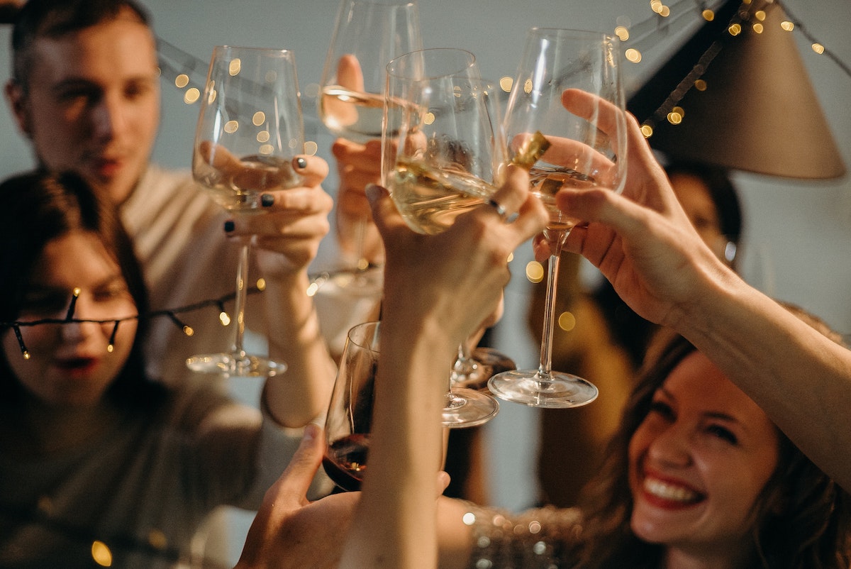 Foto: Menschen stoßen an Silvester mit Sektgläsern an