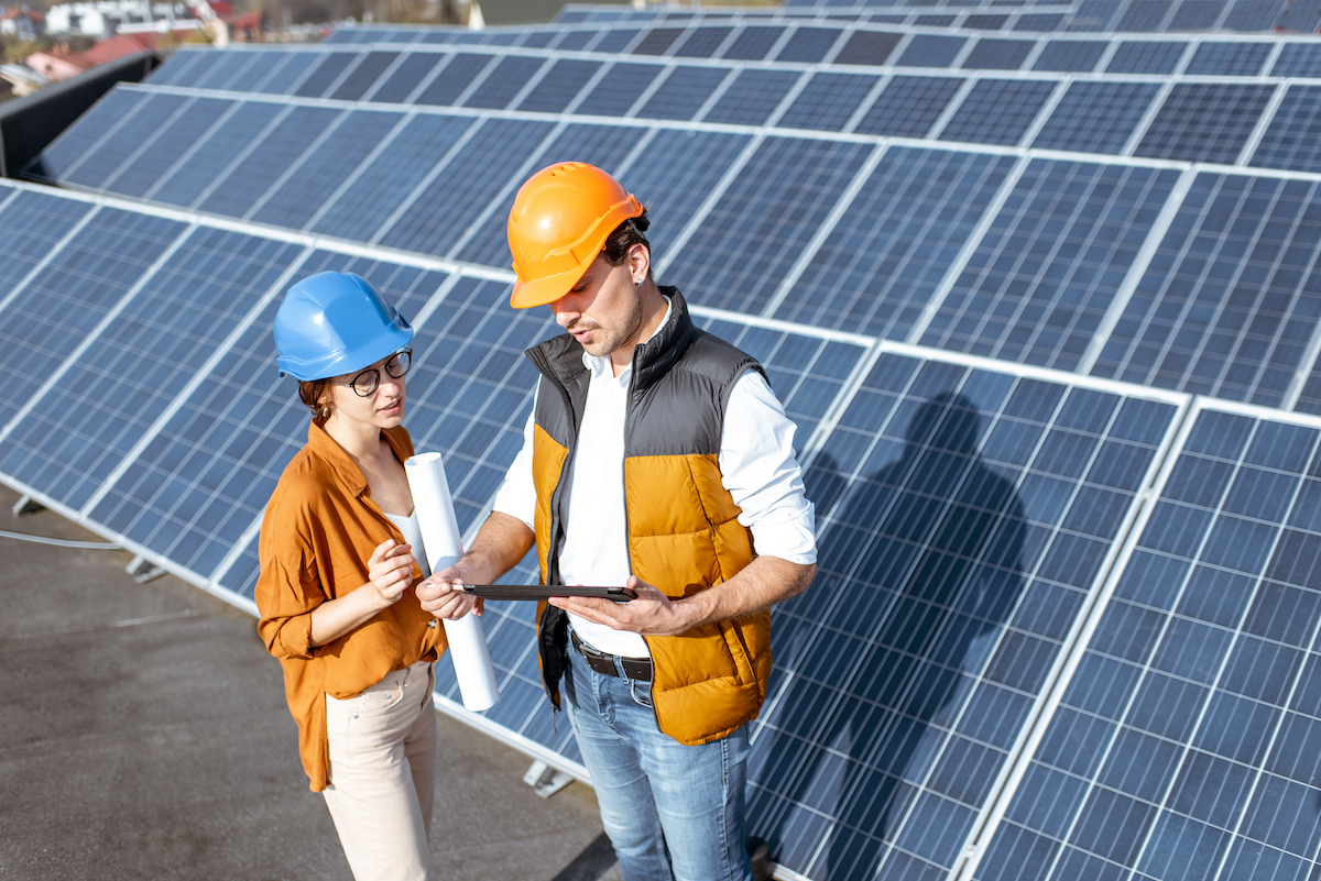 Foto: Frau und Mann arbeiten vor einer Solaranlage