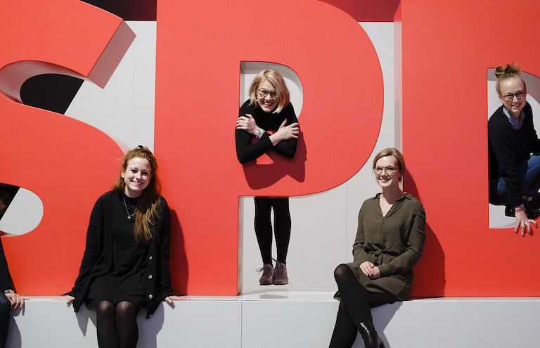 Foto: Junge Menschen sitzen am SPD-Logo