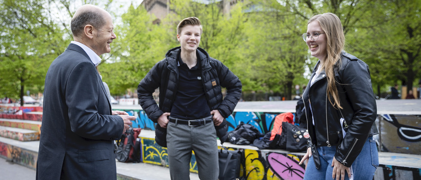 Foto: Olaf Scholz im Gespräch mit zwei jungen Menschen