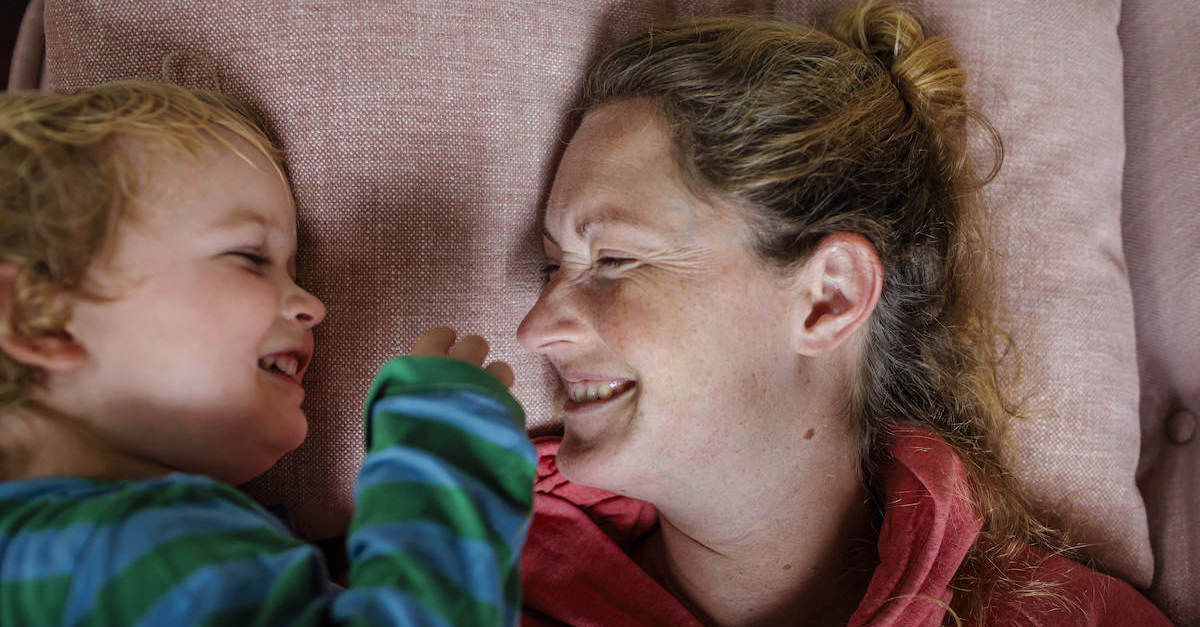 Foto: Mutter und Kind liegen auf einem Sofa