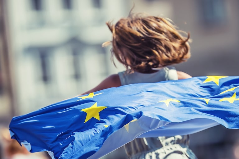 Foto: Mädchen läuft mit Europaflagge die Straße entlang