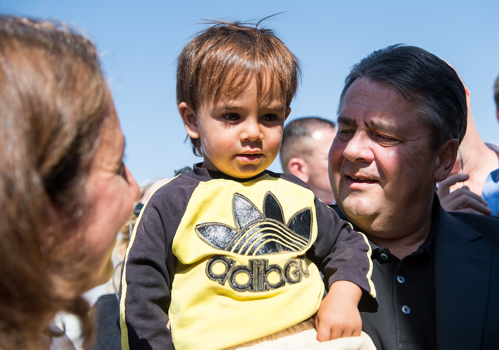 Sigmar Gabriel hält Muqnin, einen Flüchtlingsjungen aus Syrien, am 22.09.2015 bei der Besichtigung des Flüchtlingslagers Zaatari in Jordanien auf dem Arm, links daneben steht Aydan Özoguz (SPD), Staatsministerin für In