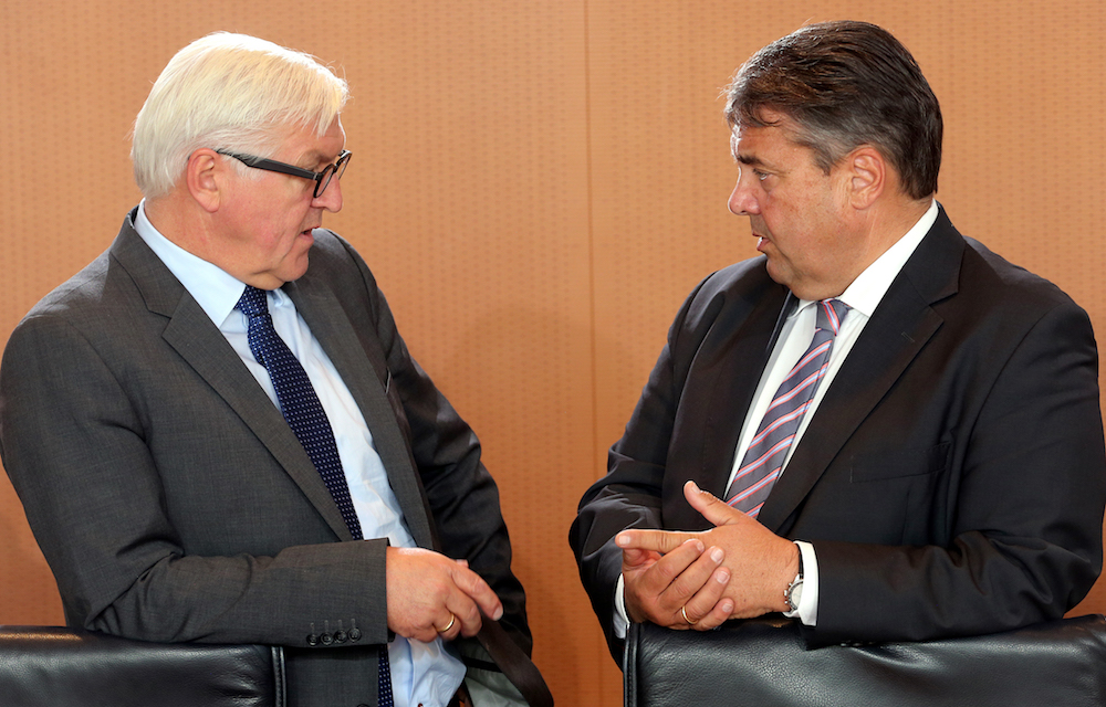 Außenminister Frank-Walter Steinmeier und Vizekanzler Sigmar Gabriel unterhalten sich auf einem Rednerpult. (Foto: dpa)