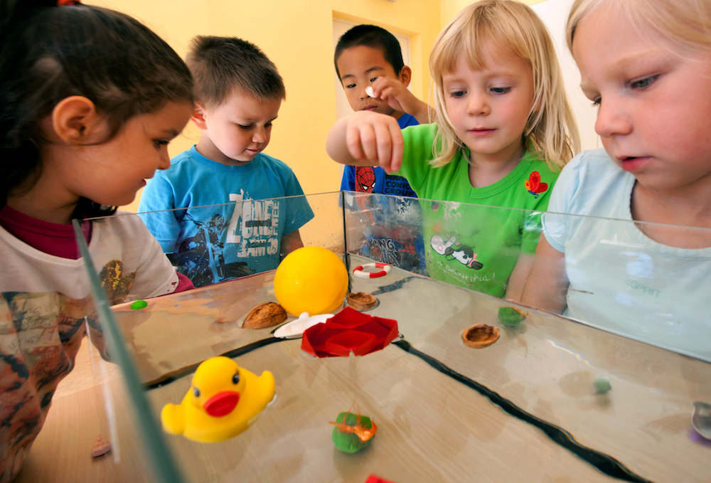 Kinder aus einer Kindertagesstätte in Ilmenau experimentieren mit der Tragfähigkeit von Wasser. (Foto:dpa)