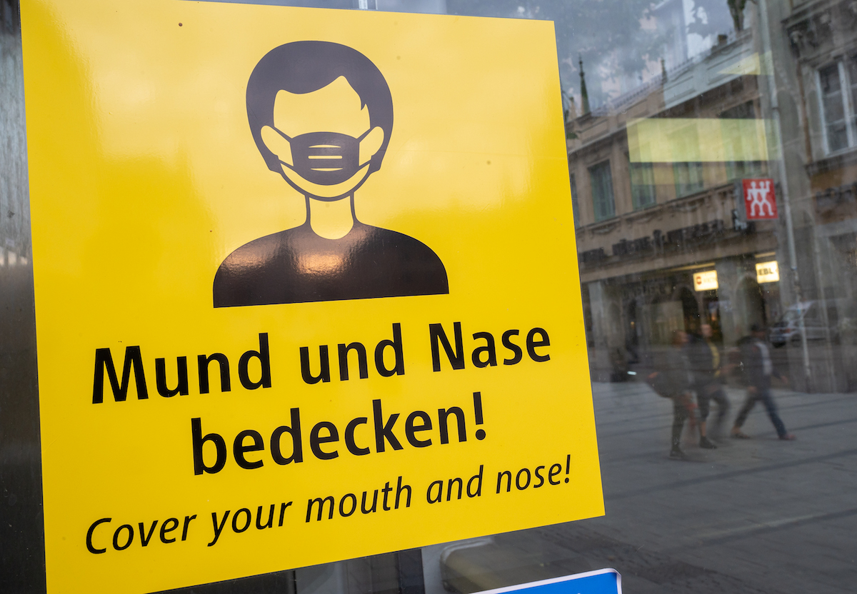 Foto: Ein Schild fordert zum Tragen einer Mund-Nasen-Bedeckung auf. 