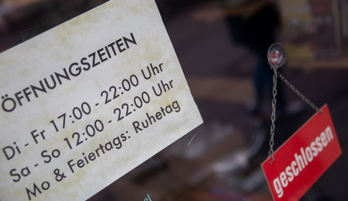 Foto: "Öffnungszeiten" und "Geschlossen" steht auf Schildern an der Tür eines Restaurants. 