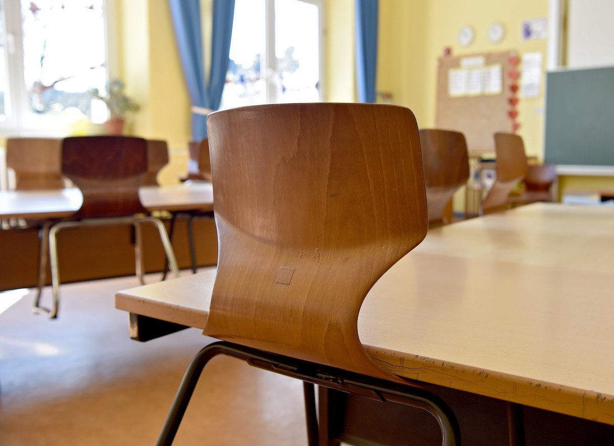 Foto: Stühle klemmen unter den Tischen in einem leeren Klassenzimmer