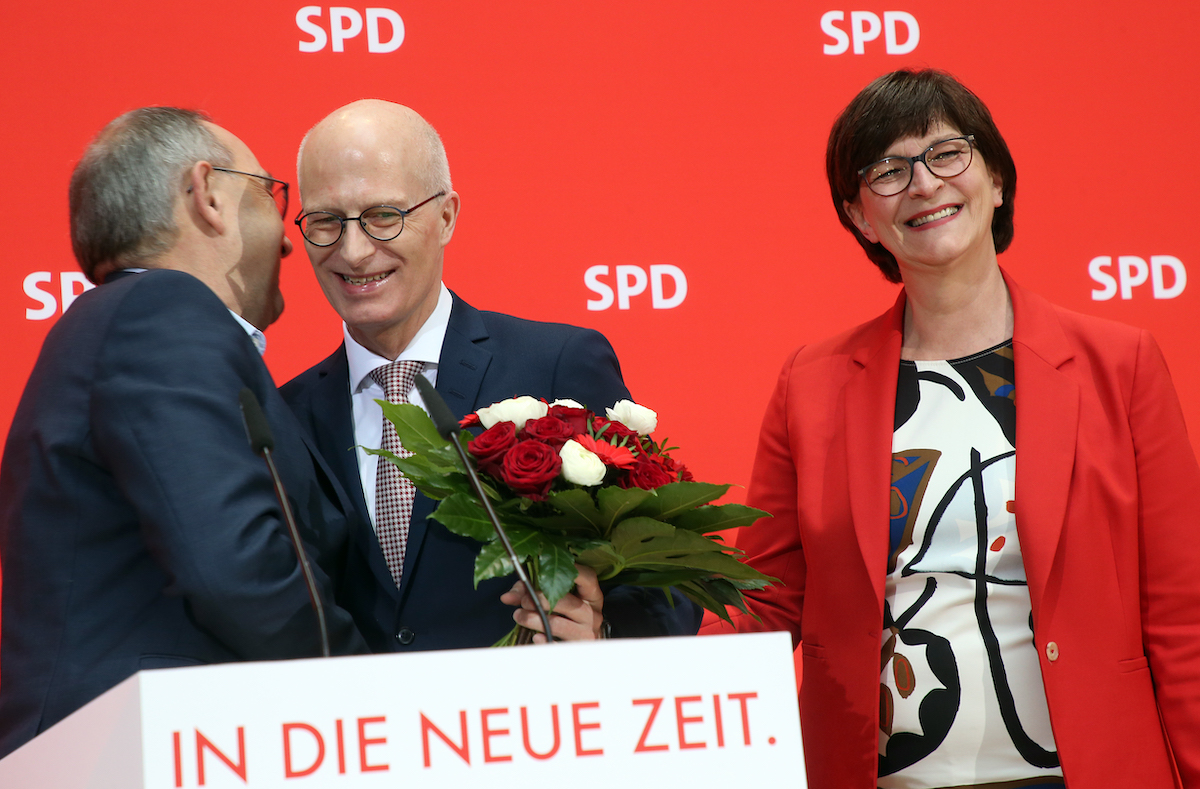 Foto: Saskia Esken und Norbert Walter-Borjans gratulieren Peter Tschentscher mit einem Blumenstrauß.
