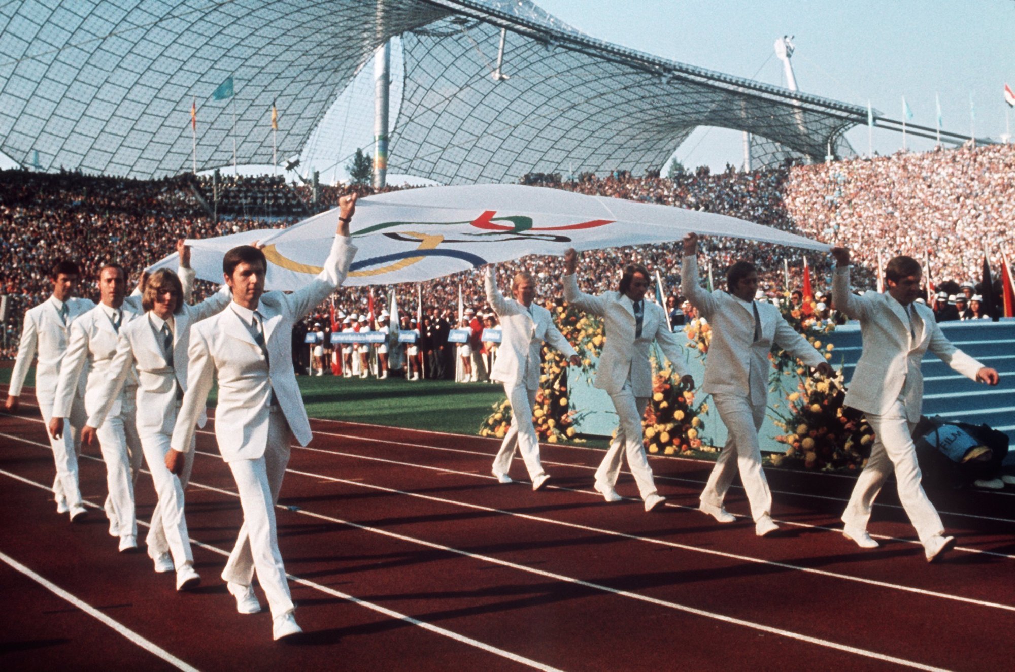 Foto: Die Mannschaft des deutschen Gold-Achters von Mexiko 1968 trägt am 26.08.1972 in München bei der Eröffnungsfeier der Olympischen Spiele die Olympia-Fahne in das Olympiastadion