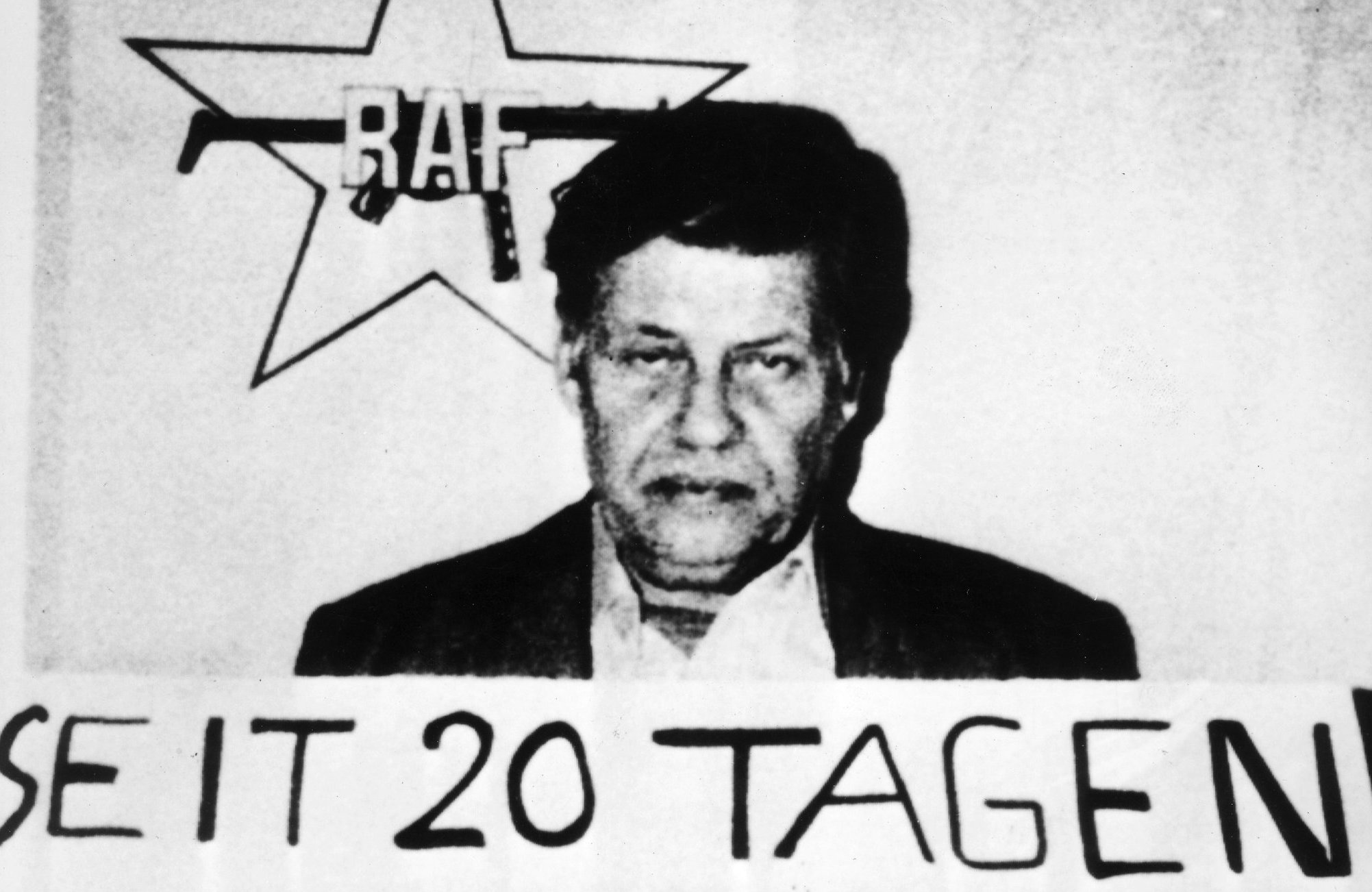 Foto: Hanns Martin Schleyer unter dem Logo der RAF (Rote Armee Fraktion) und einem Schild mit der Aufschrift "Seit 20 Tagen Gefangener der R.A.F."