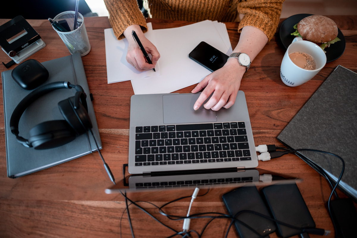 Foto: Frau sitzt mit einem Laptop an einem Tisch im Homeoffice