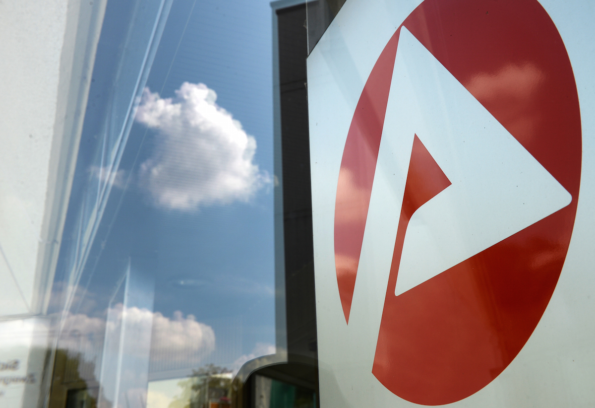 dpa Foto: Logo vom Jobcenter spiegelt sich am Eingang.