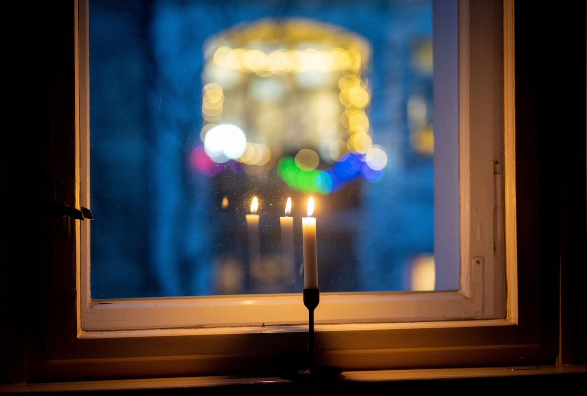 Foto: Eine Kerze brennt in einem Fenster als Zeichen des gemeinsamen Gedenkens im Rahmen der Aktion "#lichtfenster" für die Toten im Zusammenhang mit der Corona-Pandemie