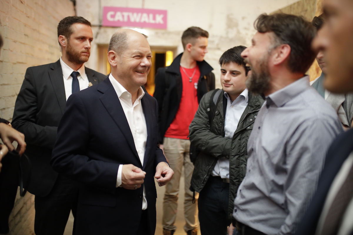 Foto: Olaf Scholz lacht mit Teilnehmern des Debattencamps