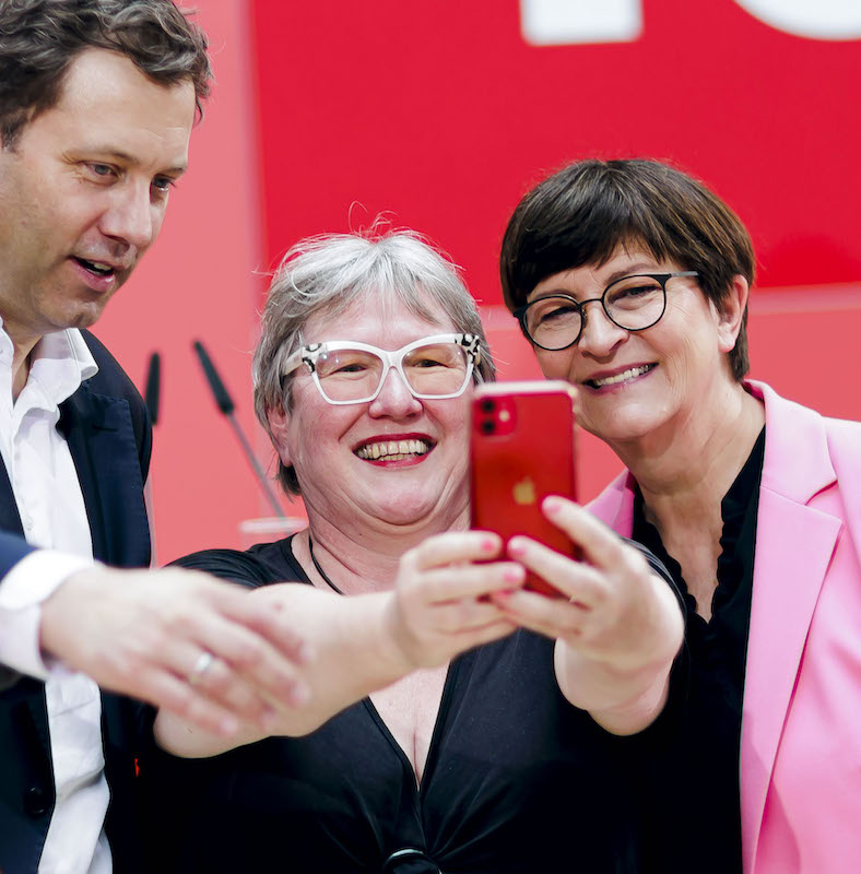 Foto: Eien Frau macht mit Saskia Esken und Lars Klingbeil ein Selfie