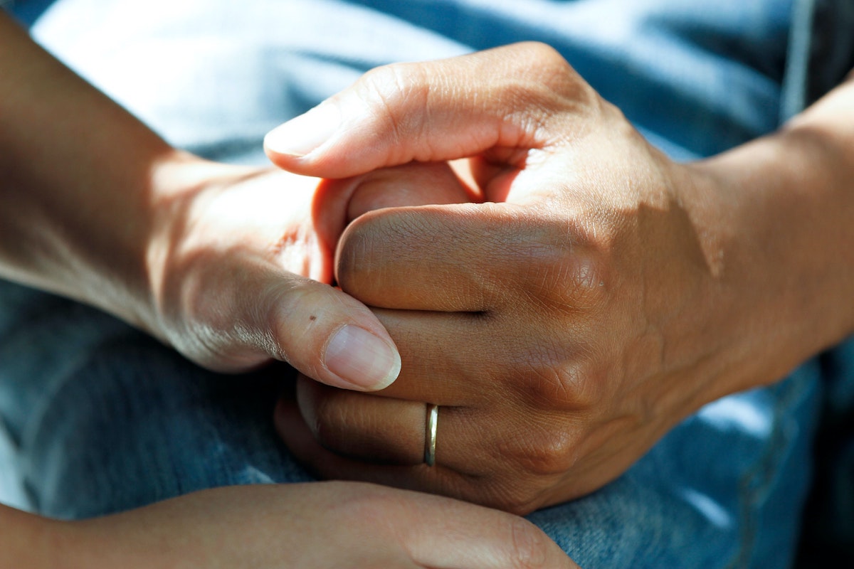 Foto: Frau tröstet Patientin mit Handdruck