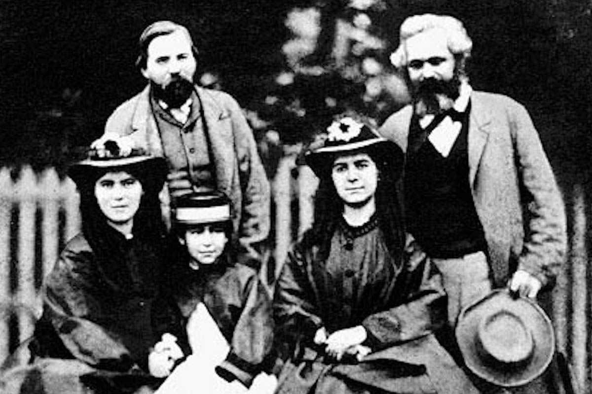 https://www.marxists.org/archive/marx/photo/family/pages/64daug.htm Foto: Karl Marx (r.) mit seinen drei Töchtern Laura, Eleanor und Jenny (vorne v.l.) und seinem Freund Friedrich Engels 1864.