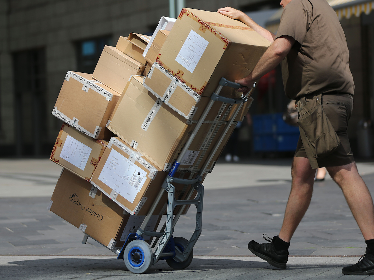 Foto: Ein Paketbote liefert Pakete aus.