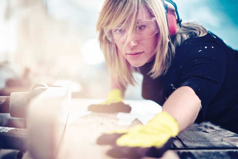 Symbolfoto Thema Arbeit: Handwerkerin arbeitet mit Gehörschutz