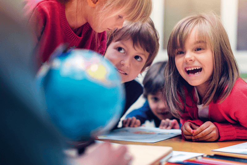 Symbolfoto Thema Bildung: Schulkinder schauen zu Lehrerin 