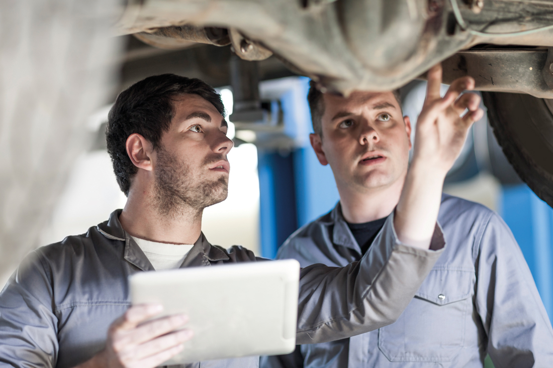 Bild: Männer mit einem Ipad reparieren ein Auto