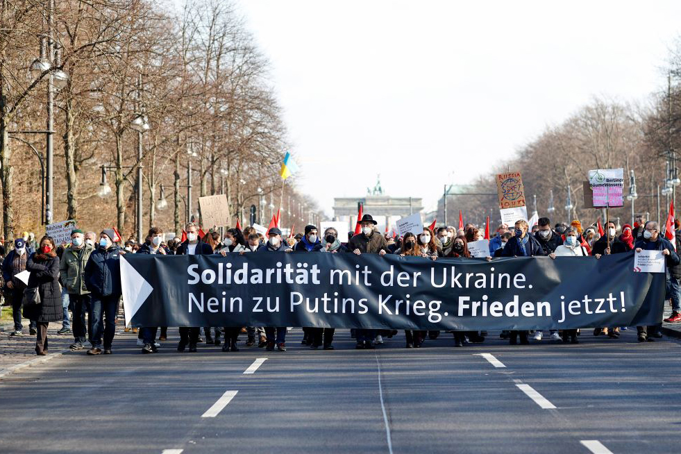 Foto: Menschen demonstrieren in Berlin mit dem Banner "Solidarität mit der Ukraine. Nein zu Putins Kried. Frieden jetzt!"