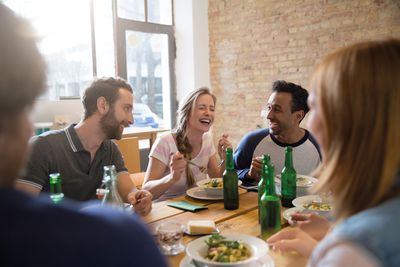 Bild: Menschen sitzen glücklich gemeinsam am Tisch